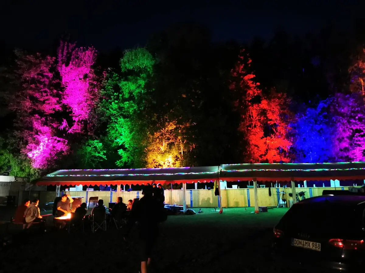 Beleuchtete Zelte und Bäume bei Nacht